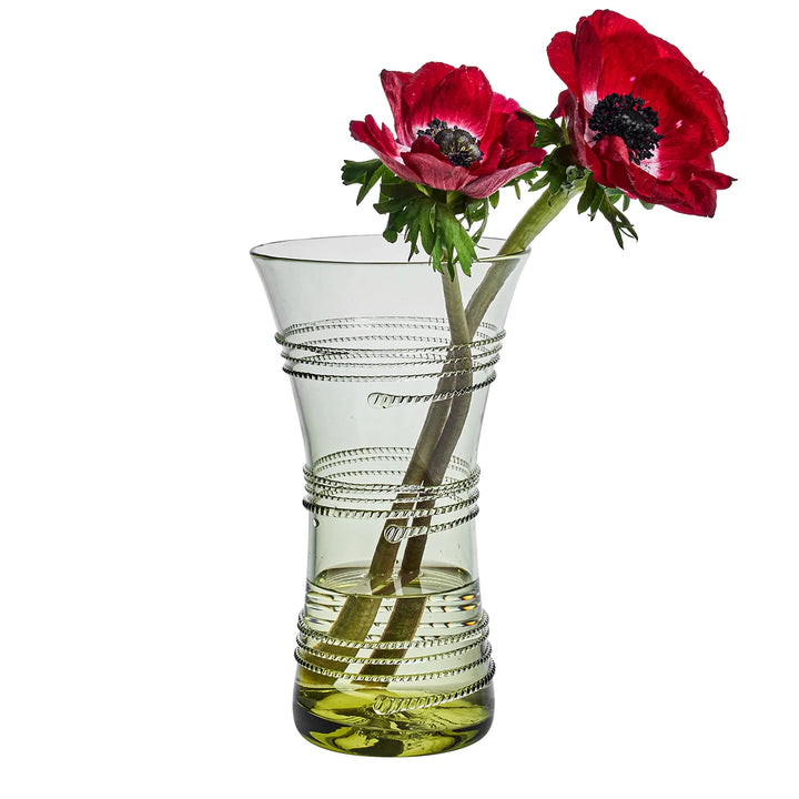 Juliska green glass vase filled with red flowers, showcasing its flared shape and wrapped glass thread detailing.