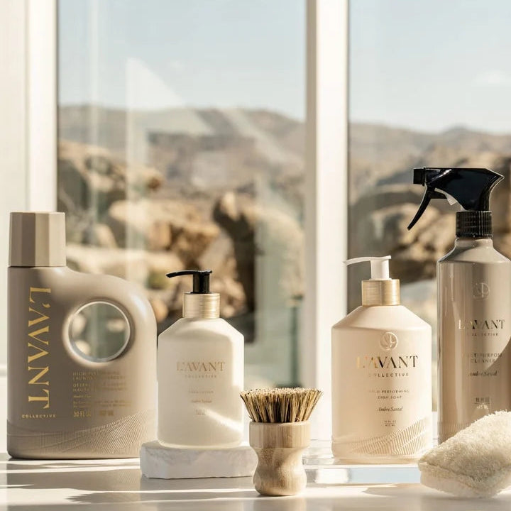 L’AVANT Ambre Santal dish soap, hand soap, multipurpose cleaner and laundry detergent displayed with cleaning brush