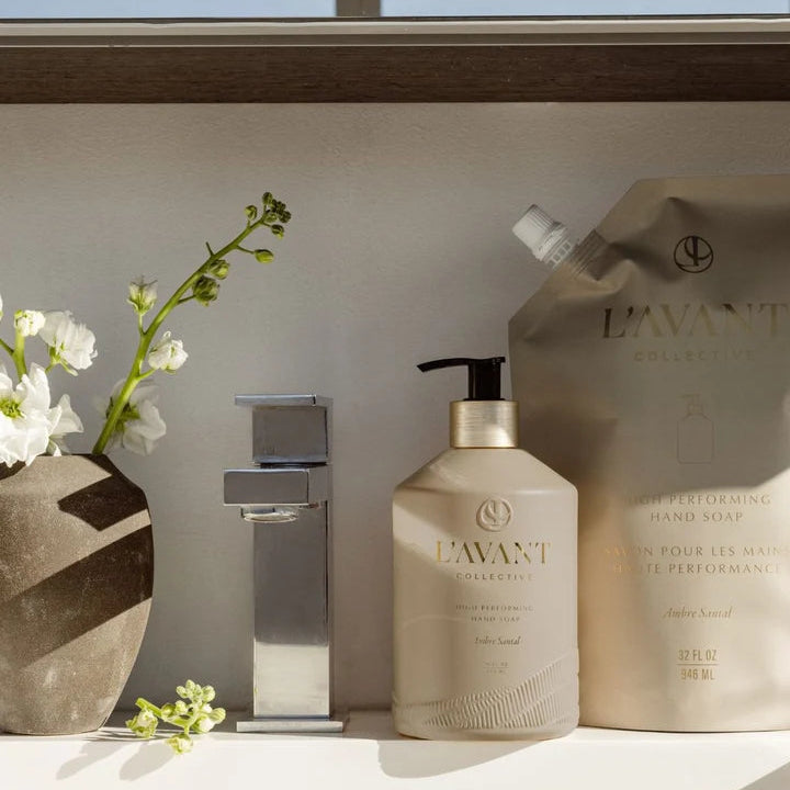 L’AVANT Ambre Santal High Performing Hand Soap bottle with 32 oz refill pouch displayed beside a modern bathroom sink