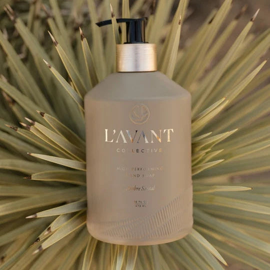 L’AVANT Ambre Santal High Performing Hand Soap 16 oz pump bottle styled outdoors with natural greenery