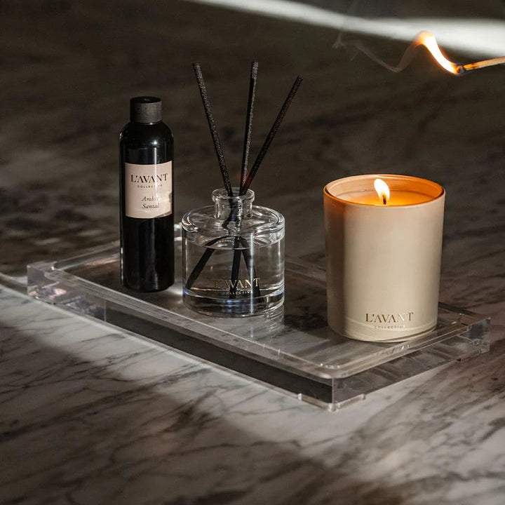 L’AVANT Collective Ambre Santal reed diffuser, fragrance refill and candle displayed on a clear acrylic tray.
