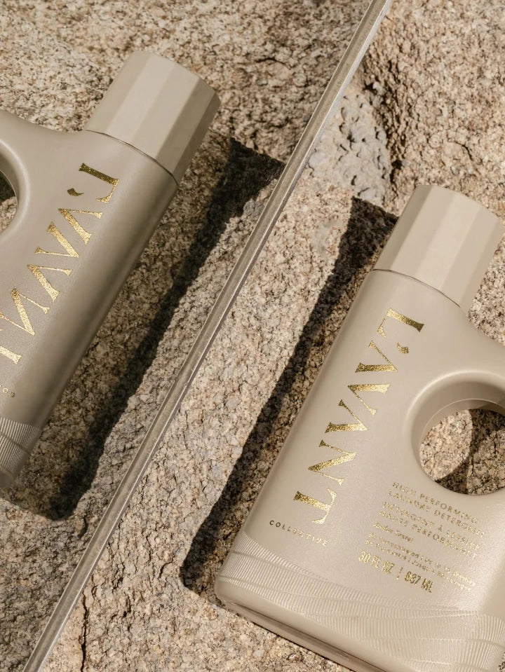 L’AVANT Collective Ambre Santal Laundry Detergent bottle displayed beside reflective glass