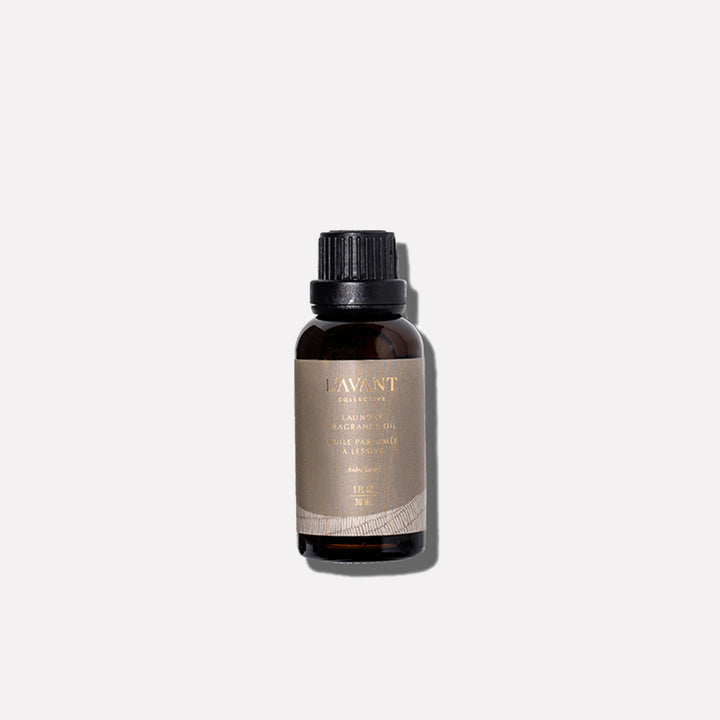 L’AVANT Collective Ambre Santal Laundry Fragrance Oil in a 1 oz amber glass bottle with black cap.