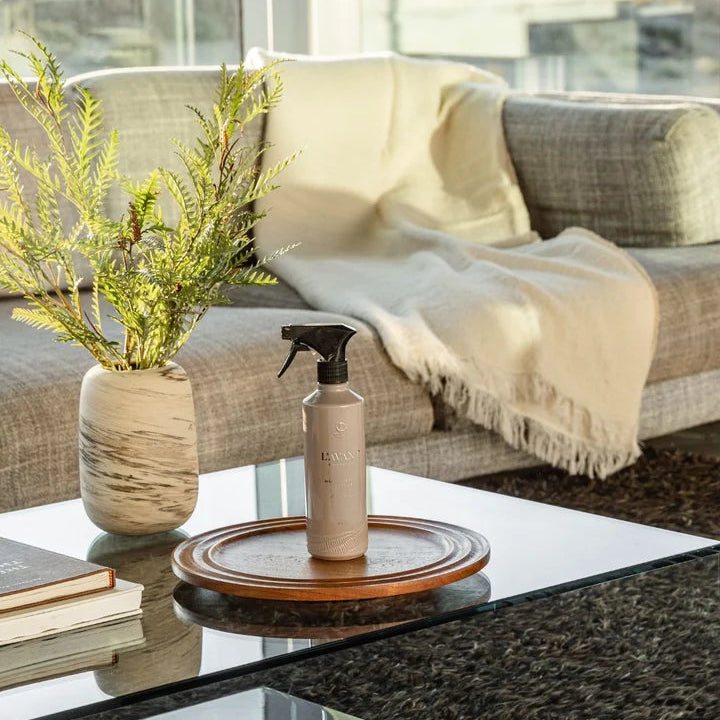 L’AVANT Collective Ambre Santal multipurpose cleaner spray displayed on a coffee table in a living room