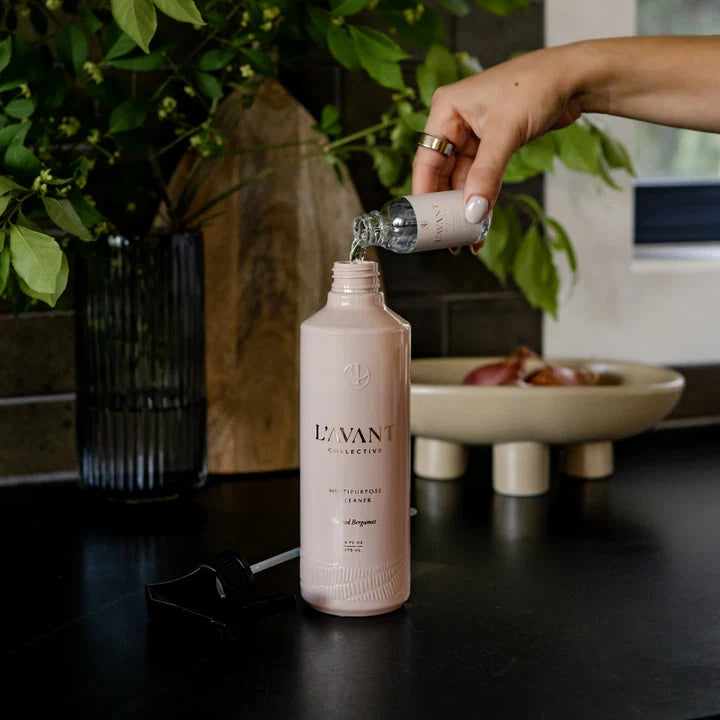 Blushed Bergamot L’AVANT multipurpose cleaner concentrate being poured into a reusable spray bottle