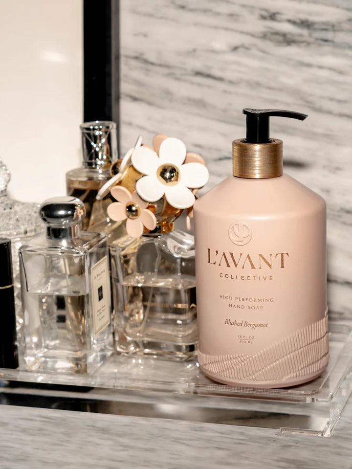 L’AVANT Blushed Bergamot High Performing Hand Soap styled on a bathroom vanity with perfume bottles