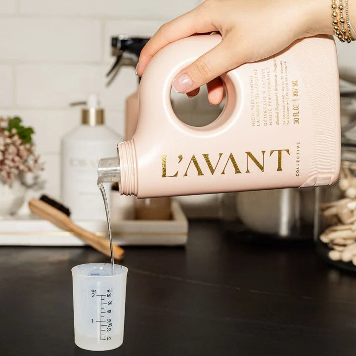 L’AVANT Collective Blushed Bergamot Laundry Detergent being poured into a measuring cup