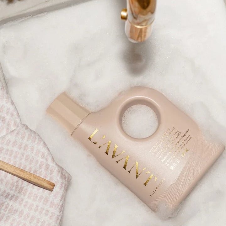 L’AVANT Collective Blushed Bergamot Laundry Detergent bottle styled in a sink with suds