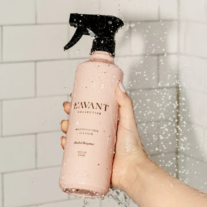 L’AVANT Blushed Bergamot Multipurpose Cleaner held under water in a tiled shower