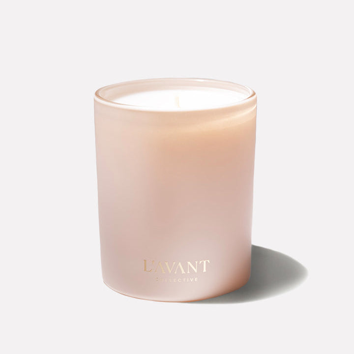 L’AVANT Collective Blushed Bergamot scented candle in a soft blush glass vessel with gold logo.