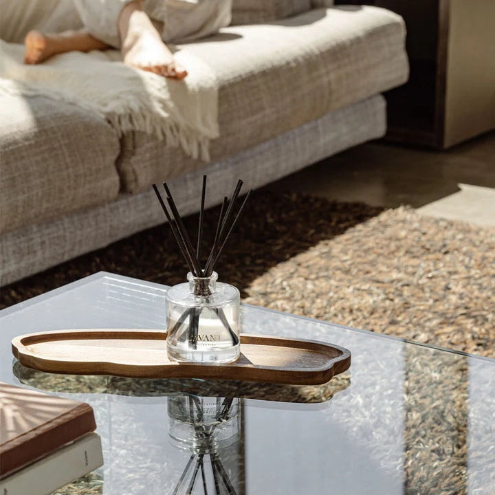L’AVANT Collective reed diffuser with black reeds styled on a coffee table in a neutral living room.