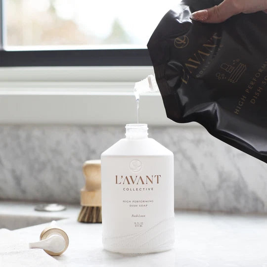 L’AVANT Fresh Linen Dish Soap Refill being poured into a reusable dish soap bottle