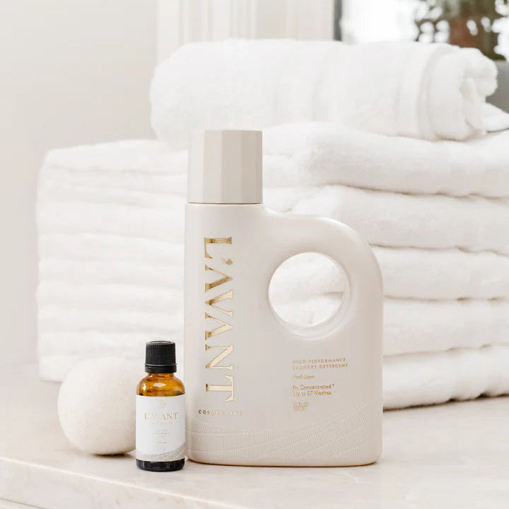L’AVANT Collective Fresh Linen laundry detergent and Laundry Fragrance Oil styled with wool dryer balls and fresh white towels.