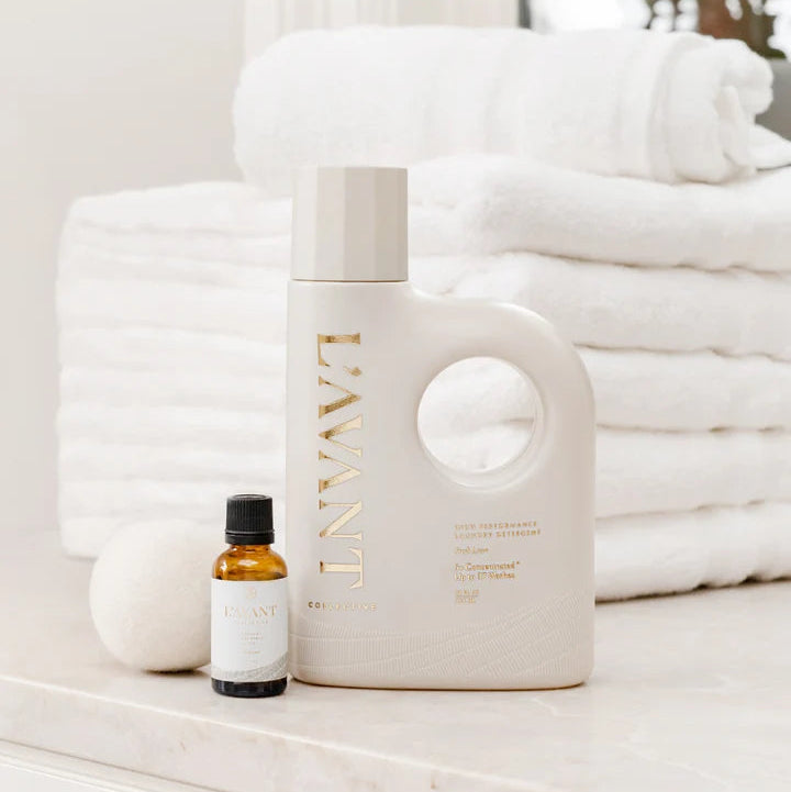L’AVANT Collective Fresh Linen Laundry Detergent with laundry fragrance oil, wool dryer ball and folded white towels