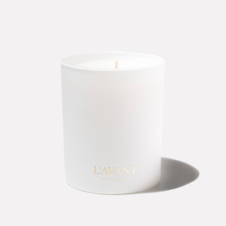 L’AVANT Collective Fresh Linen scented candle in a white glass vessel with gold logo on a clean background.