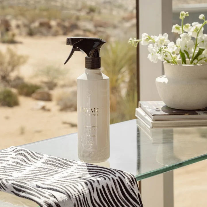L’AVANT Multipurpose Cleaner beside cleaning cloth on a glass tabletop