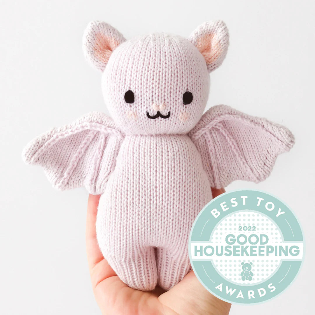 Lavender knitted baby bat stuffed animal featuring a Good Housekeeping Best Toy Award badge
