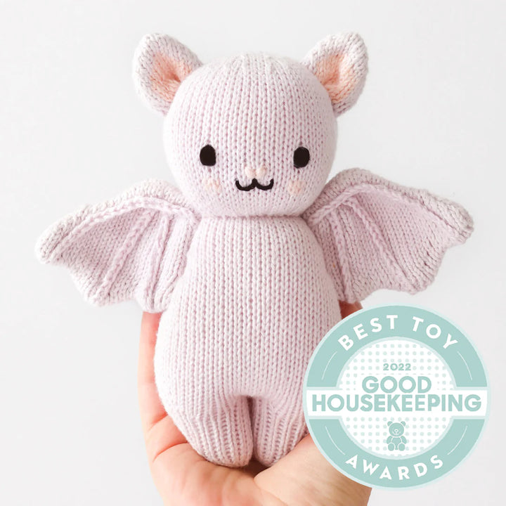 Lavender knitted baby bat stuffed animal featuring a Good Housekeeping Best Toy Award badge