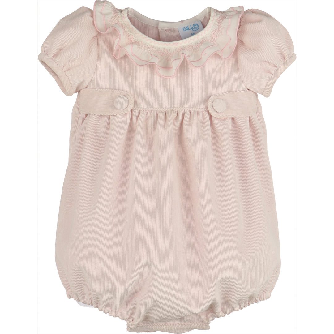 Front view of light pink corduroy baby girl bubble with white smocked ruffle collar, puff sleeves, covered button tabs, and elastic leg openings.