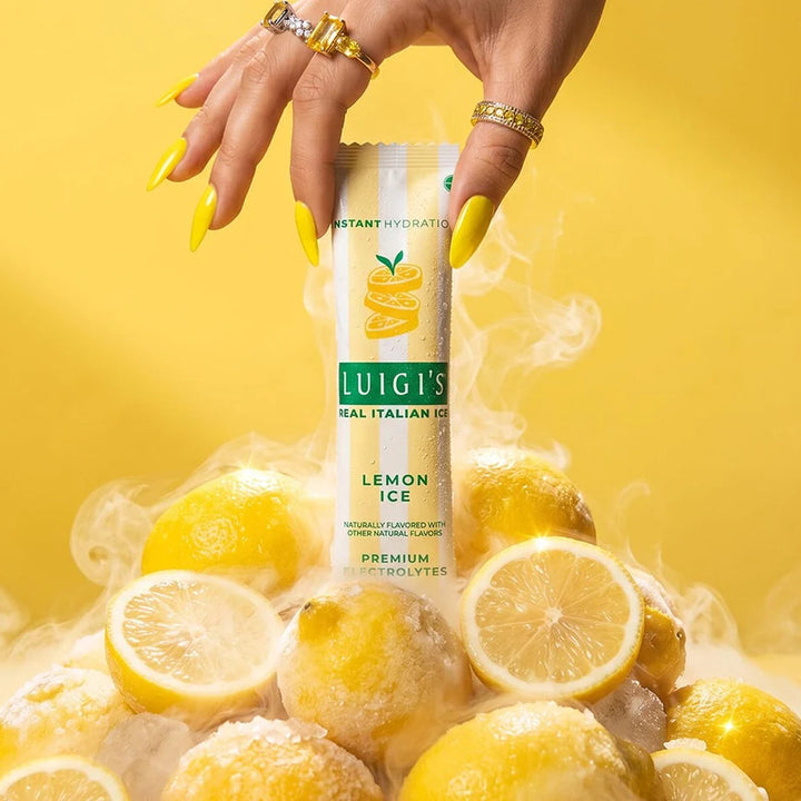 Luigi’s Lemon Ice premium electrolyte drink mix stick packet displayed with fresh lemons