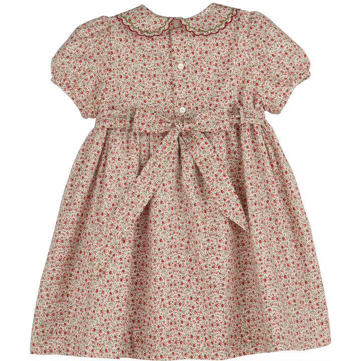 Back of Mulberry Floral Smocked Dress featuring red floral print, scalloped collar, button closure, and tie-back sash