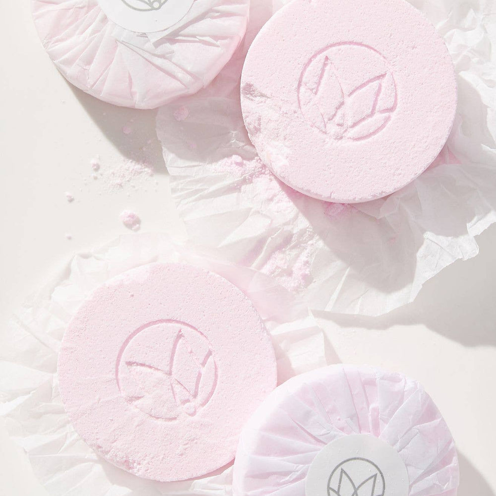 Musee's Champagne and Rose Shower Steamers unwrapped and laying on a white surface.
