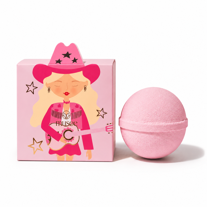 Musee cowgirl-themed surprise bath balm in a pink Western-style box with a pink bath balm sphere.