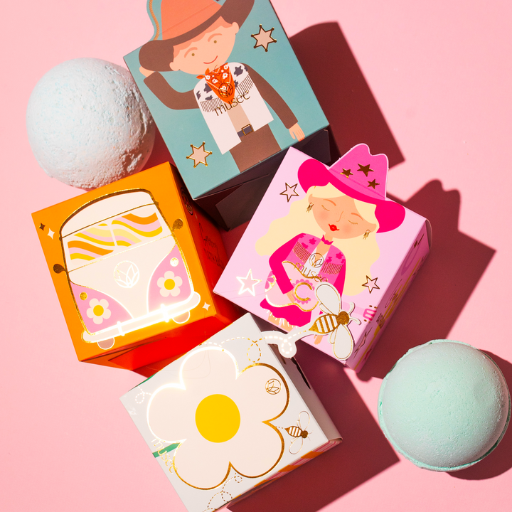 Musee cowgirl-themed surprise bath balm in a pink Western-style box displayed next to the other box options. 