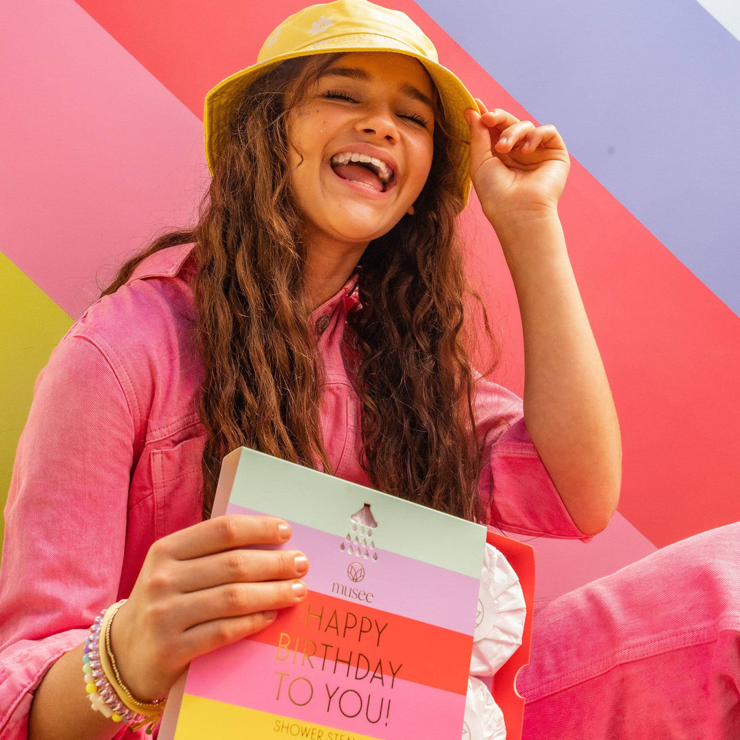Teen smiling while holding on to Musee&