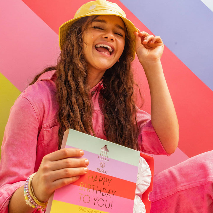 Teen smiling while holding on to Musee&