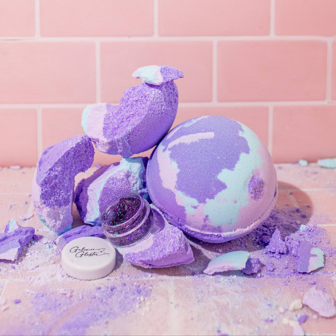 Musee Lavender Haze surprise bath balm unwrapped and places next to a broken one, surprise body/hair glitter revealed. 