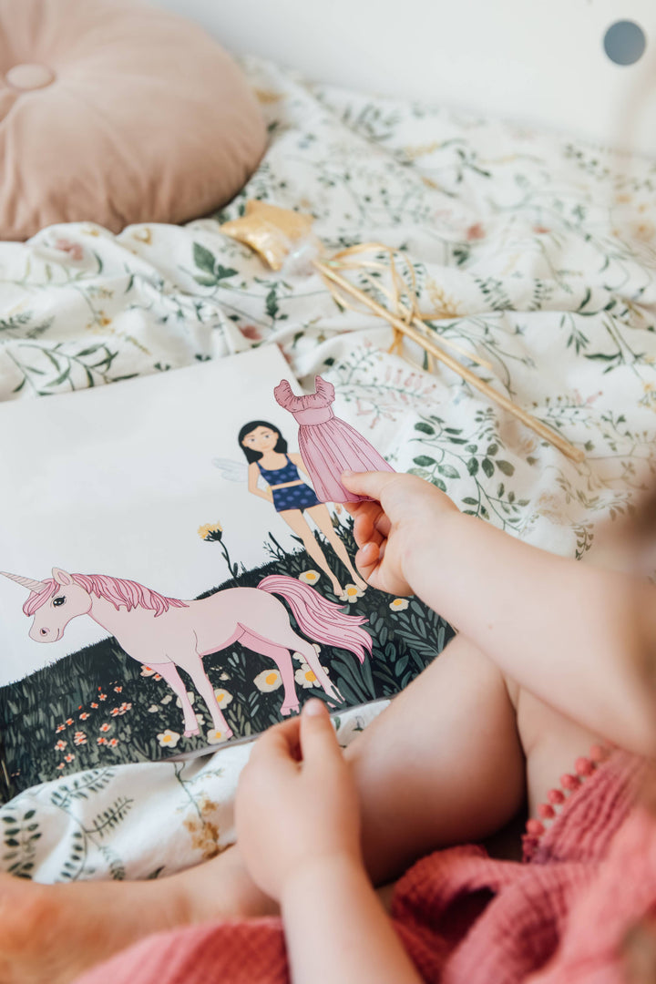 Child using a reusable dress sticker in My Sticker Storybook Fairies and Unicorns