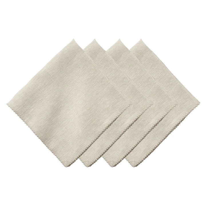 Set of four natural linen napkins featuring a delicate neutral crochet trim around the edges