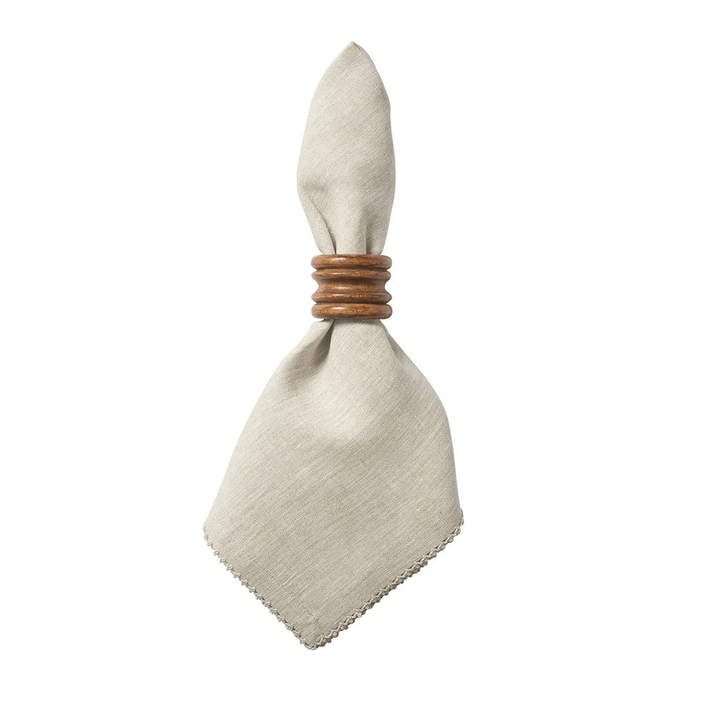 Natural linen dinner napkin with delicate crochet edging styled with a warm wood napkin ring