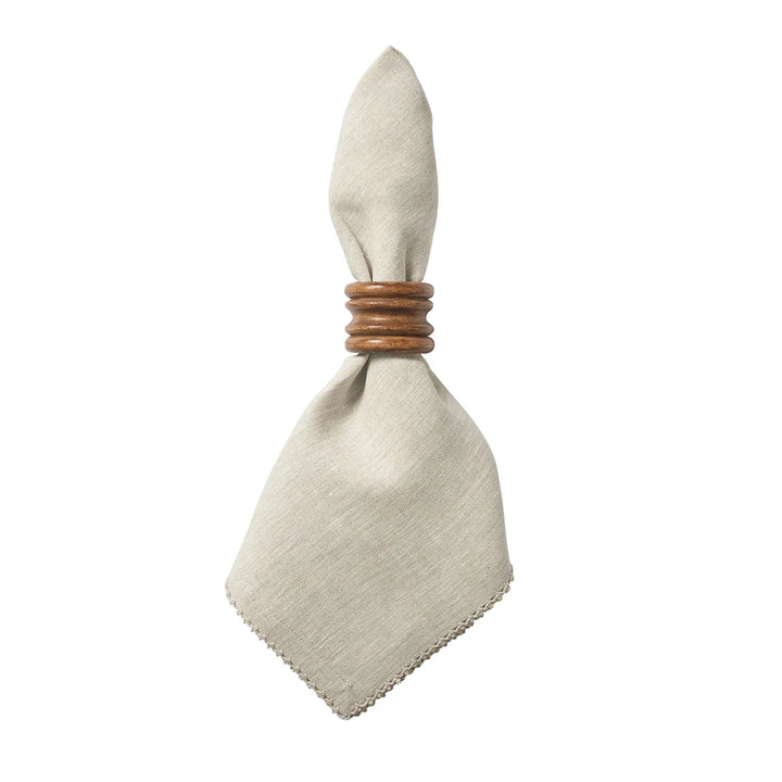 Natural linen dinner napkin with delicate crochet edging styled with a warm wood napkin ring