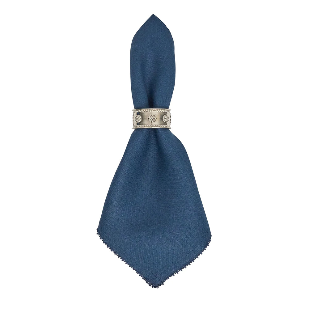 Navy blue linen dinner napkin with crochet edging displayed in a decorative silver napkin ring