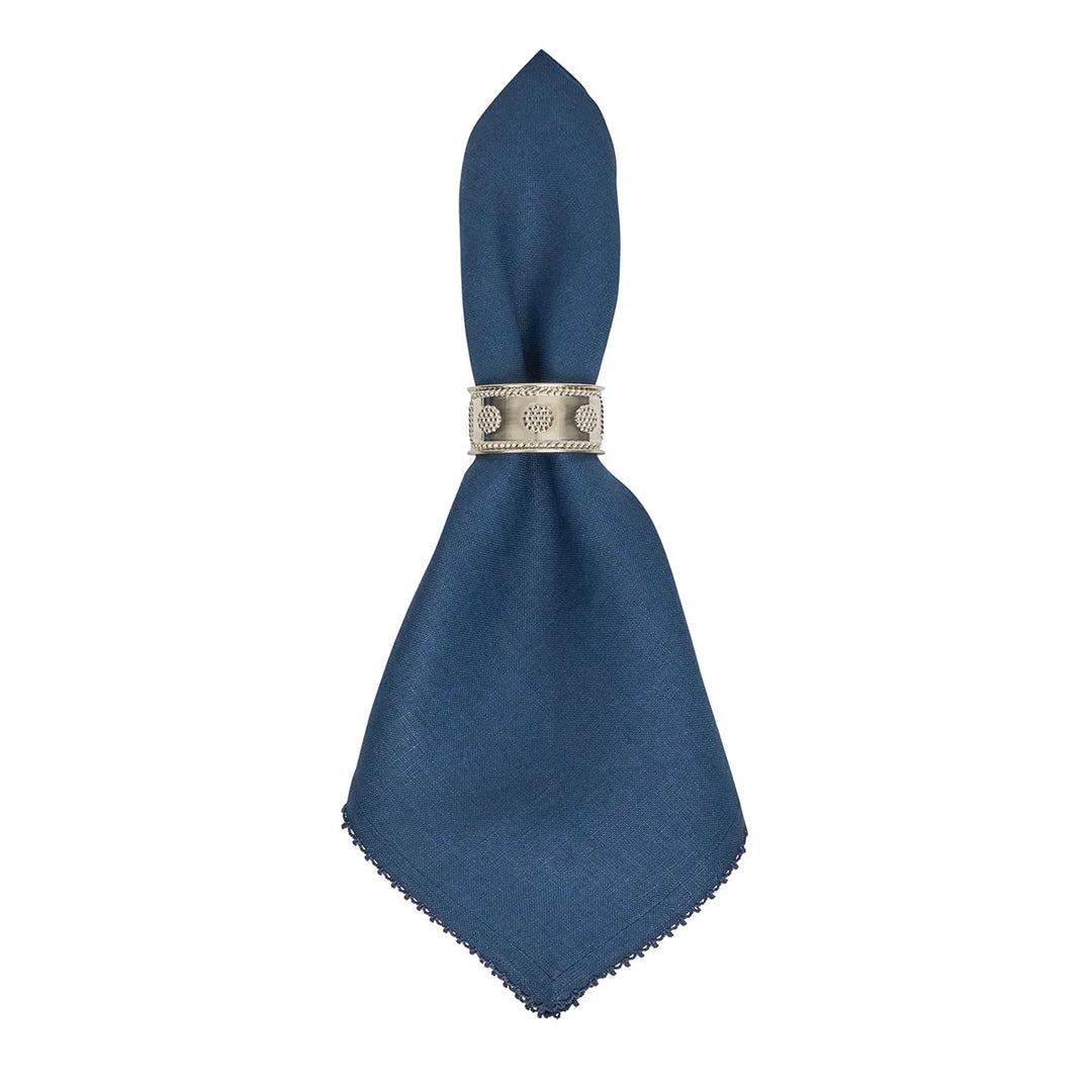 Navy blue linen dinner napkin with crochet edging displayed in a decorative silver napkin ring