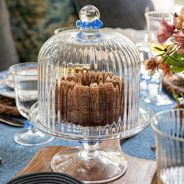 Nell Ruffle Chambray cake dome and stand styled on an elegant tablescape with coordinating blue tableware