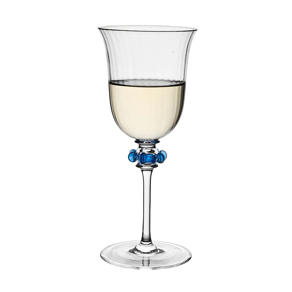 Nell Ruffle Wine Glass in Chambray showcasing textured ribbed glass, a slender stem, and sculptural blue ruffle detailing.