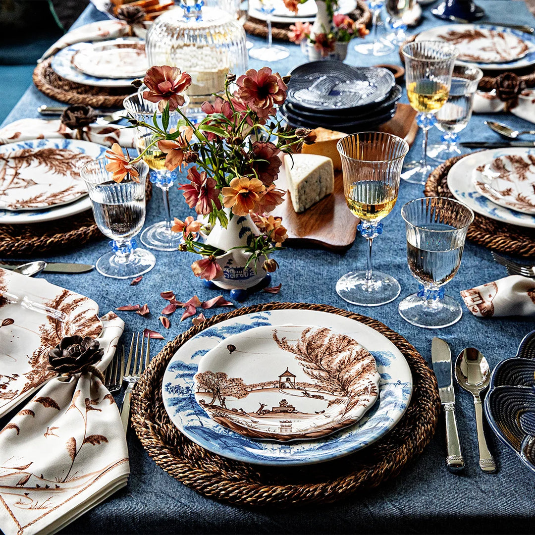 Nell Ruffle Wine Glass in Chambray displayed in an elegant tablescape with coordinating blue glassware and decorative table accents.