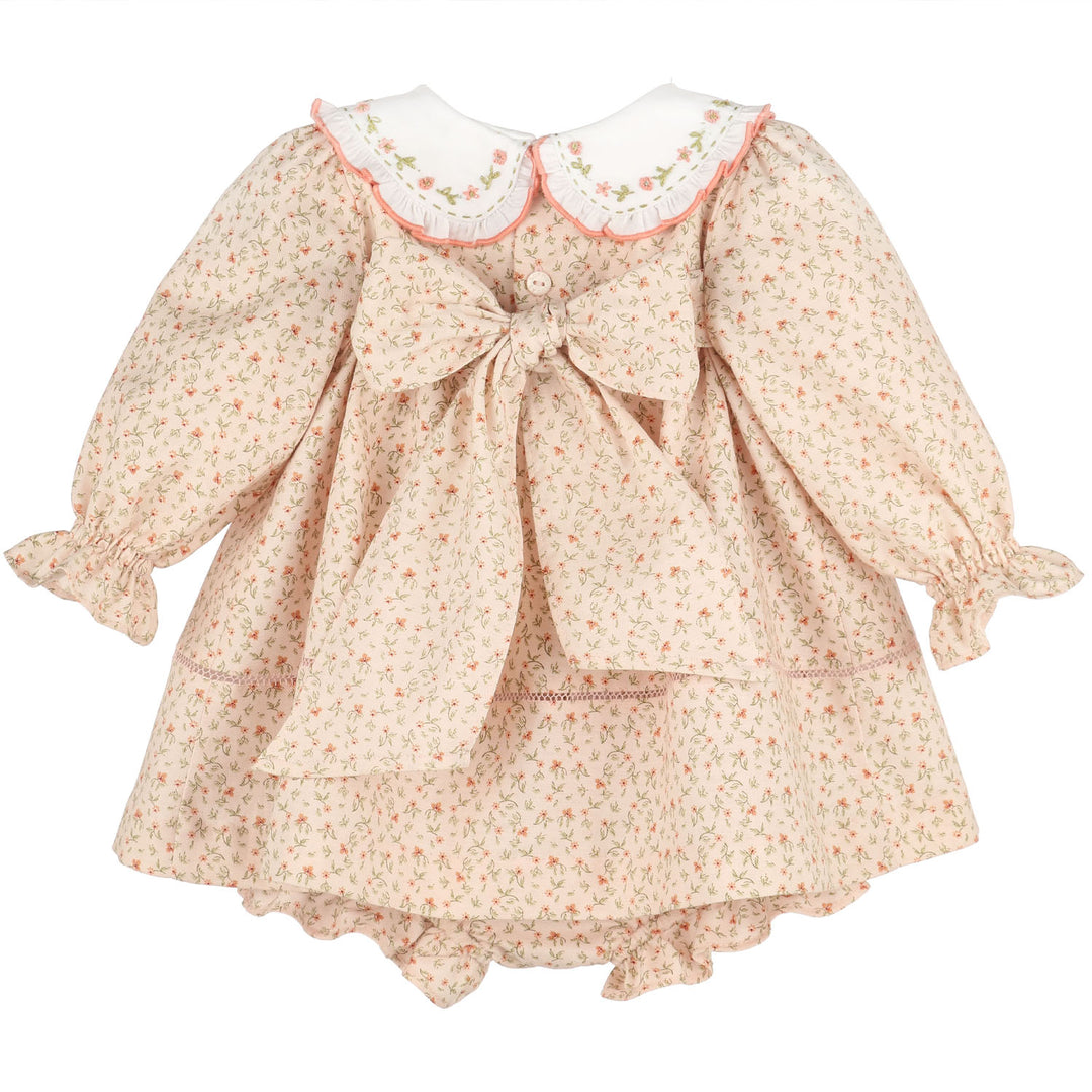 Back view of Orange Pumpkin Patch Playdate Float featuring an embroidered white collar, long ruffled sleeves, floral print, oversized back bow, and matching bloomer.