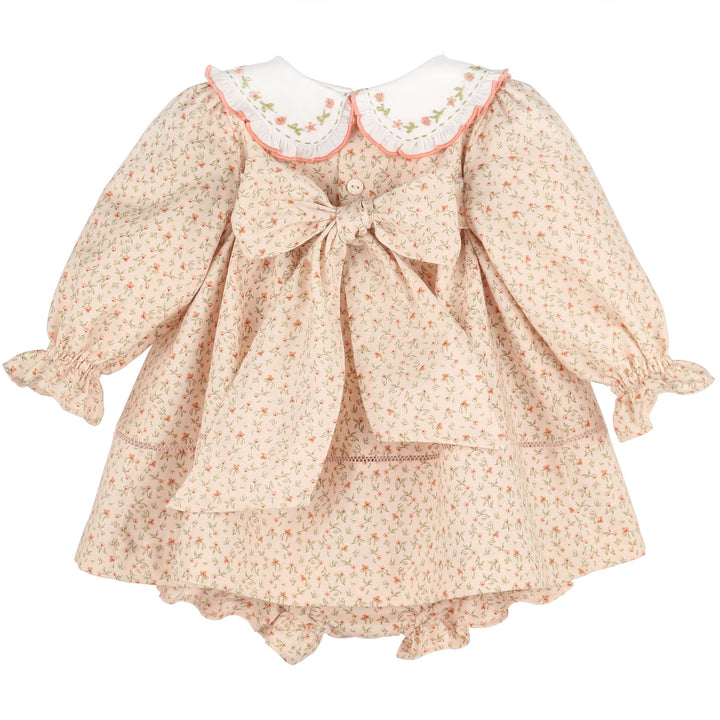 Back view of Orange Pumpkin Patch Playdate Float featuring an embroidered white collar, long ruffled sleeves, floral print, oversized back bow, and matching bloomer.