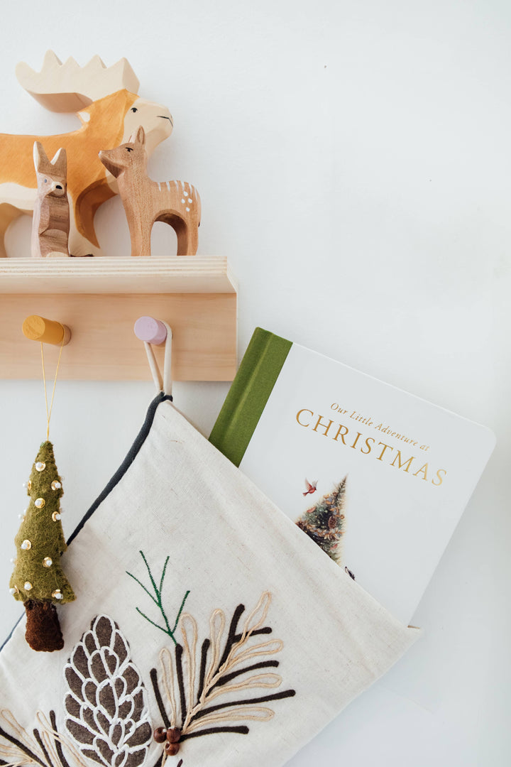 Our Little Adventure at Christmas book styled with wooden woodland animals and Christmas nursery decor