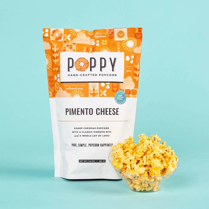 Poppy Pimento Cheese Hand-Crafted Popcorn bag with a bowl of cheesy popcorn