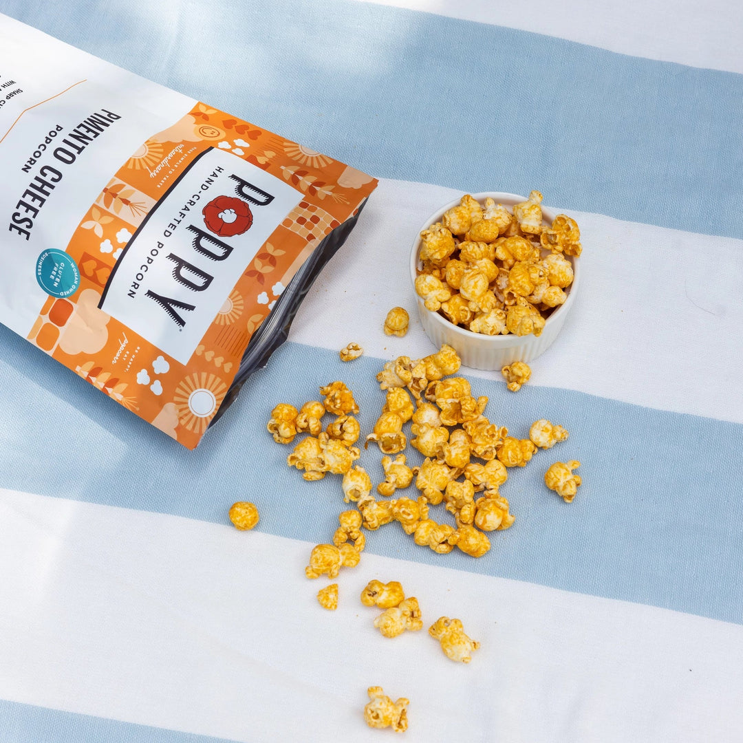 Close-up of Pimento Cheese Hand-Crafted Popcorn coated in savory sharp cheddar and pimento seasoning.