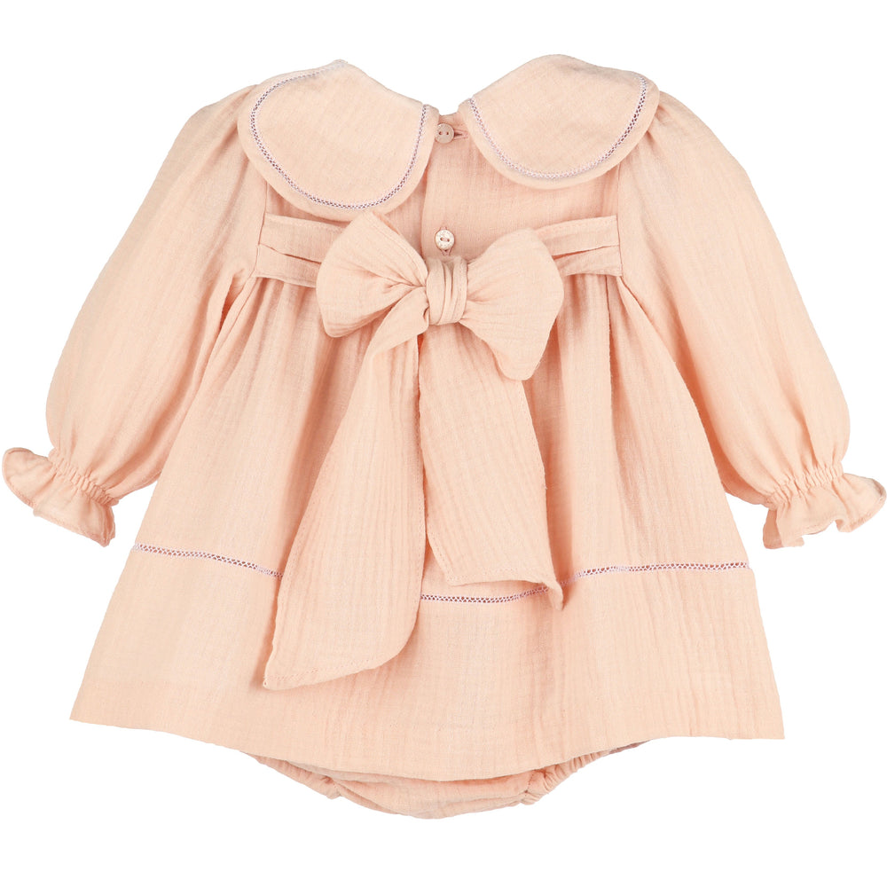 Back view of Pink Cuddle Cotton Petal Float featuring a petal collar, long ruffled sleeves, button closure, and oversized statement bow.
