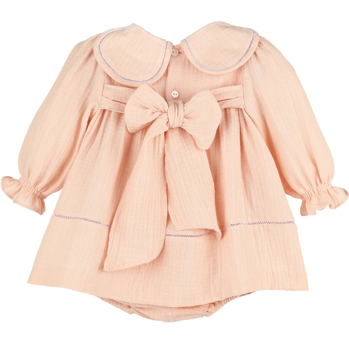 Back view of Pink Cuddle Cotton Petal Float featuring a petal collar, long ruffled sleeves, button closure, and oversized statement bow.
