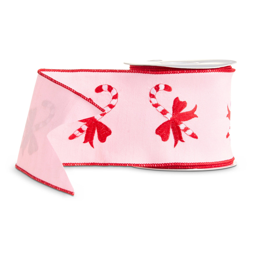 Light pink wired Christmas ribbon featuring embroidered red and white candy canes tied with festive red bows and finished with bright red wired edges.