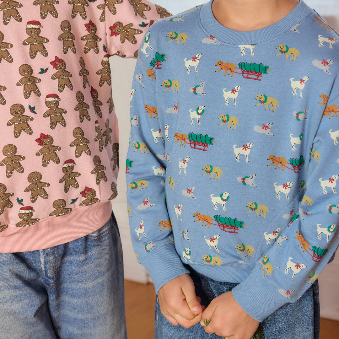 Close-up of child wearing blue Holiday Labs Play Sweatshirt featuring Christmas Labrador dogs and tree sleds, paired with denim jeans.