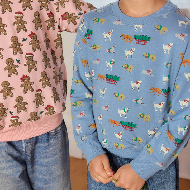 Close-up of child wearing blue Holiday Labs Play Sweatshirt featuring Christmas Labrador dogs and tree sleds, paired with denim jeans.